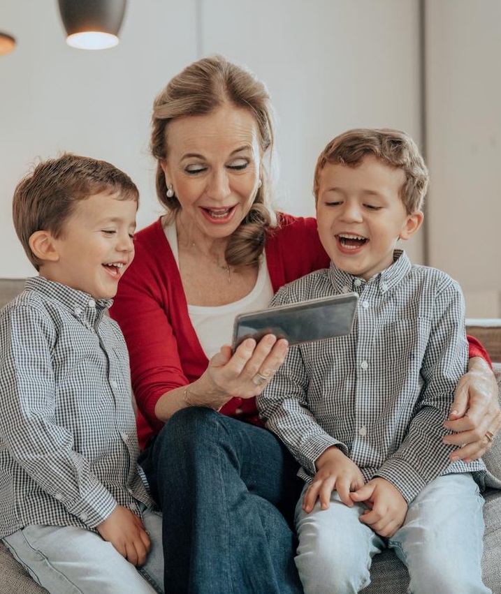 Een grootmoeder raadpleegt haar bank online met haar kleinkinderen 