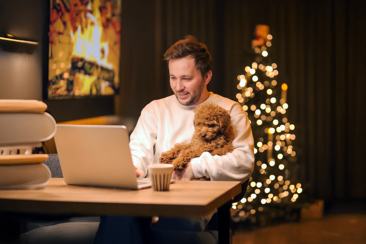 Man met hond achter laptop