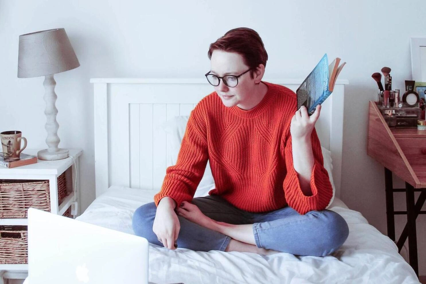 Vrouw op laptop  met een boek