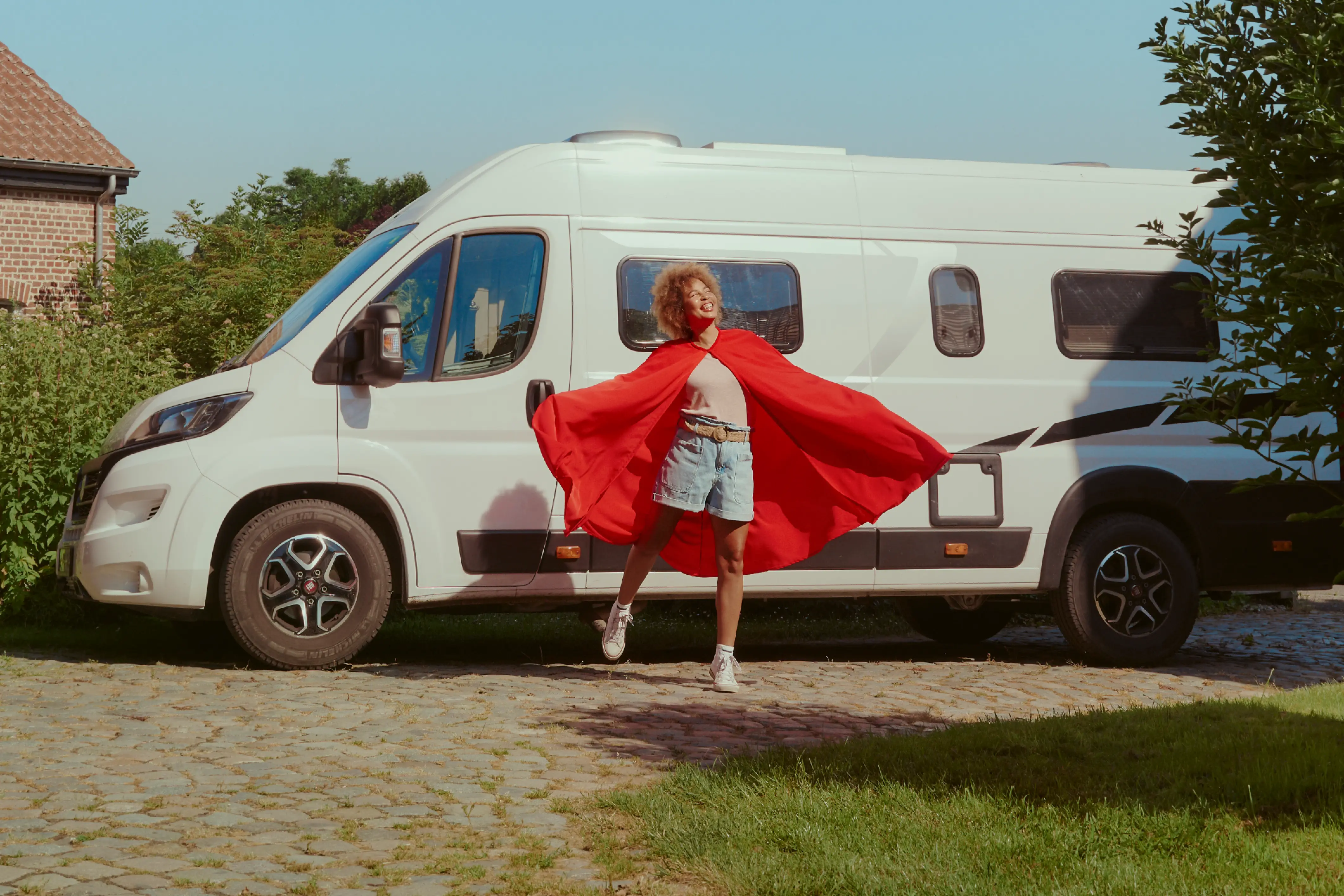 Vrouw in superheldencape voor busje 